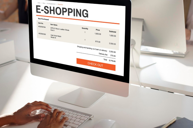 Person checking out online with an e-shopping order summary displayed on a desktop screen.