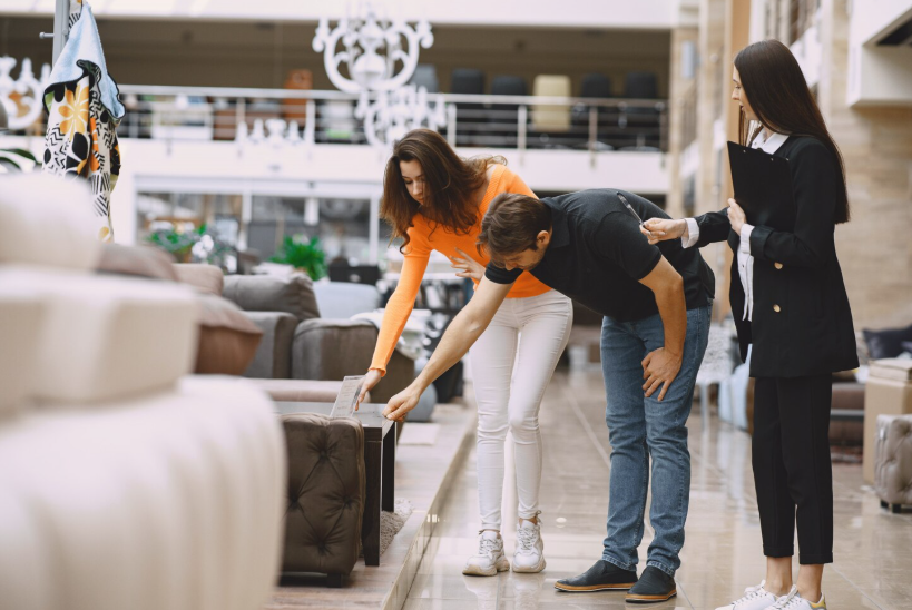 Shoppers inspecting furniture in a showroom while looking for open box furniture deals.