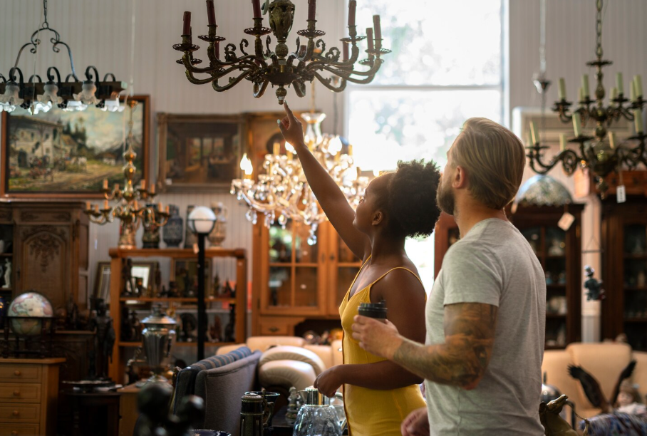 Couple shopping for secondhand furniture and home décor at a thrift store.