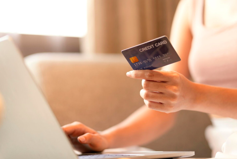 Holding a credit card while shopping online, highlighting hidden card perks like purchase protection.