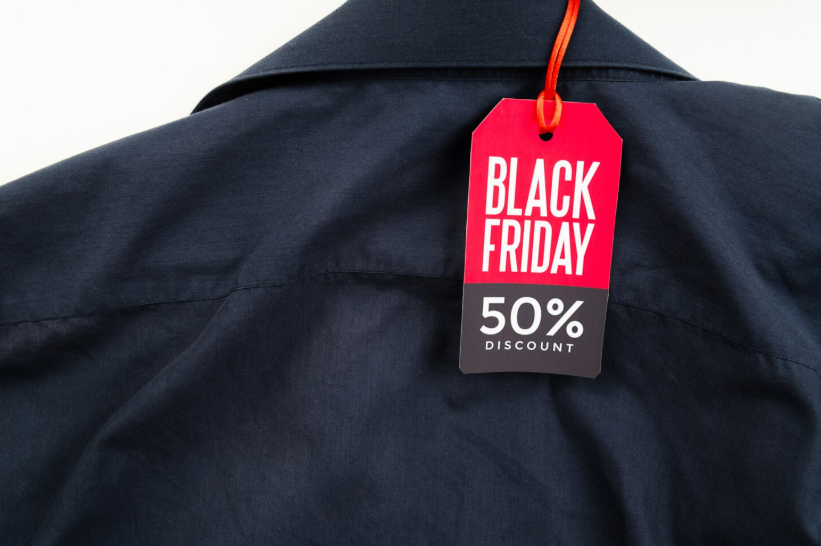 Black friday sale tag showing a 50 percent discount attached to a shirt, illustrating anchor pricing.