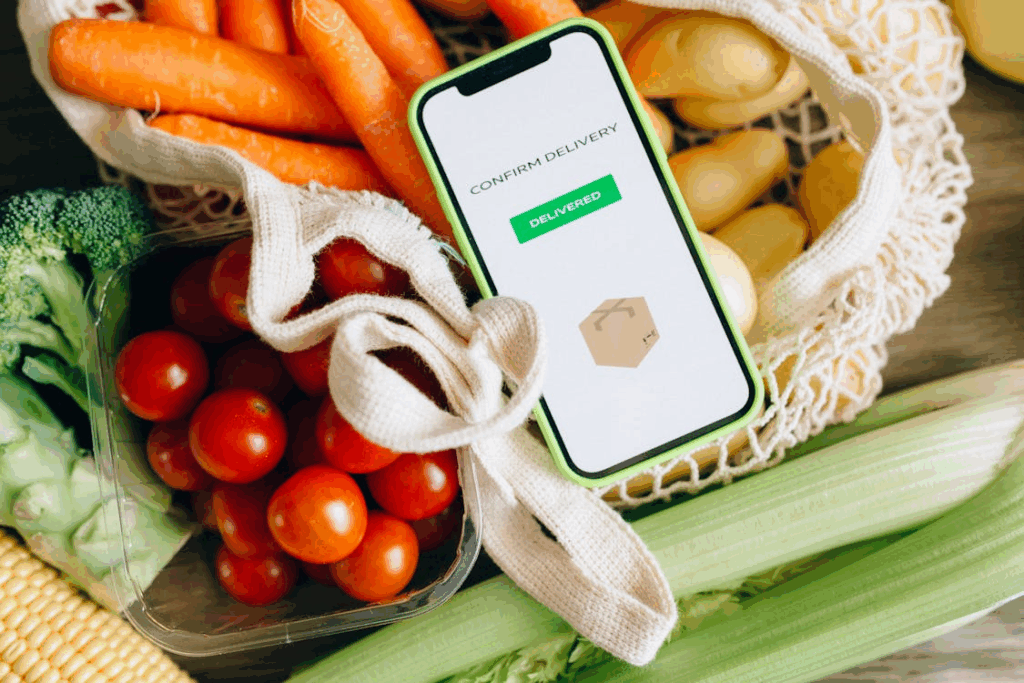Smartphone confirming grocery delivery placed on fresh produce, showing completed delivery status.